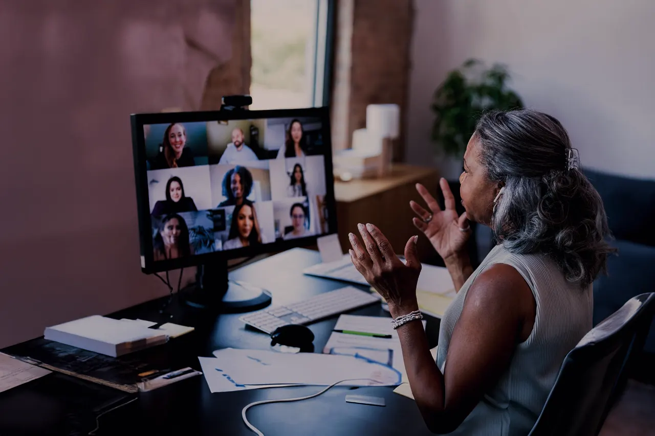 A host presenting to a grid of attendees on a video call at an online event